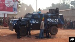 A young man wounded by passing Chadian troops lies beside a Republic of Congo police vehicle, during a protest outside Mpoko Airport in Bangui, Central African Republic, Dec. 23, 2013.