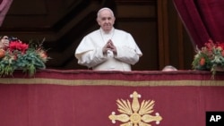 Pope Francis looks at the crowd before delivering the Urbi et Orbi (Latin for 'to the city and to the world' ) Christmas' day blessing from the main balcony of St. Peter's Basilica at the Vatican, Dec. 25, 2021.