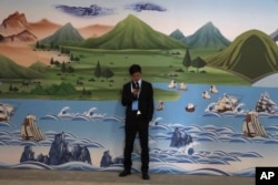A man stands near a mural depicting the ancient Silk Road during the Second Belt and Road Forum in Beijing, April 26, 2019.