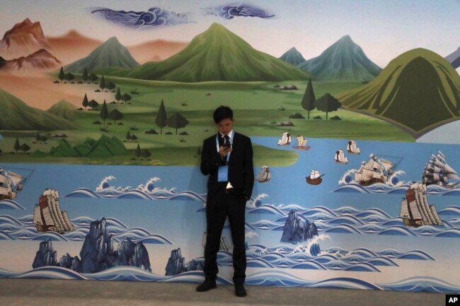 A man stands near a mural depicting the ancient Silk Road during the Second Belt and Road Forum in Beijing, April 26, 2019.