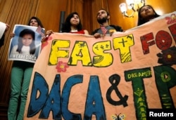 DACA beneficiaries hold up a sign after an event by Democrats calling for congressional Republicans to bring forward immigration legislation on Capitol Hill in Washington, Sept. 6, 2017.