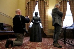 Reporter Bryan Sears, left, takes a cellphone photograph of a bronze statue of abolitionist Harriet Tubman during a private viewing ahead of its unveiling at the Maryland State House, Monday, February 10, 2020, in Annapolis, Maryland.