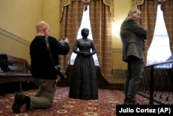 Reporter Bryan Sears, left, takes a cellphone photograph of a bronze statue of abolitionist Harriet Tubman during a private viewing ahead of its unveiling at the Maryland State House, Monday, February 10, 2020, in Annapolis, Maryland.