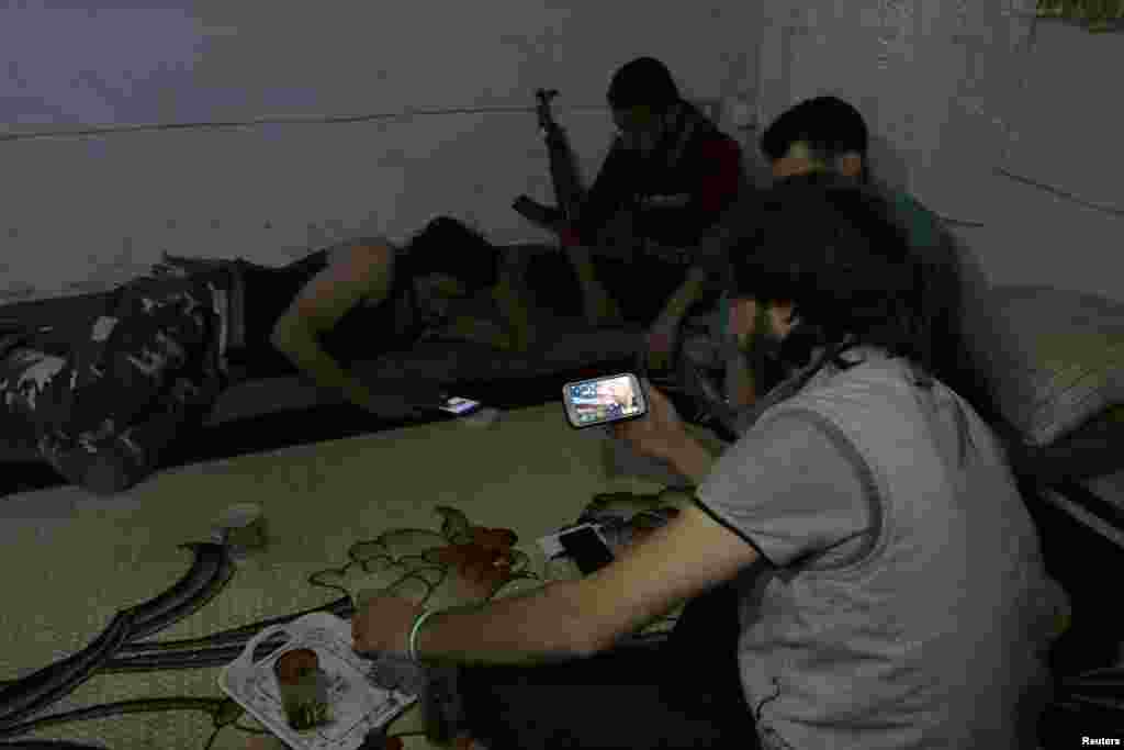 A Harakat Nour al-Din al-Zenki fighter watches on his smart phone news about Donald Trump's election as president, in the rebel held beseiged area in Aleppo, Syria, Nov. 9, 2016.