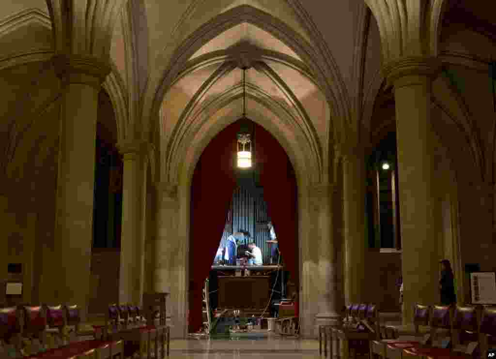 William Adair of Gold Leaf Studios and his staff work to remove green paint from the organ in the Washington National Cathedral's historic Bethlehem Chapel, July 30, 2013. 