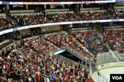 Volunteers and students excitedly watching the hockey game