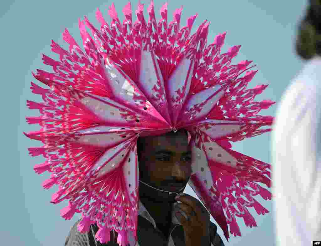 A spectator with a head ornament watches a match during the fifth and final day-night international match between Pakistan and New Zealand at the Zayed International Cricket Stadium in Abu Dhabi, UAE.