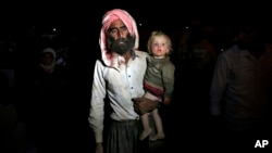 Displaced Iraqis from the Yazidi community cross the Syria-Iraq border in northern Iraq. A U.N. panel says the Islamic State is committing genocide, crimes against humanity and other war crimes against the Yazidi community in Iraq and Syria, Aug. 10, 2014