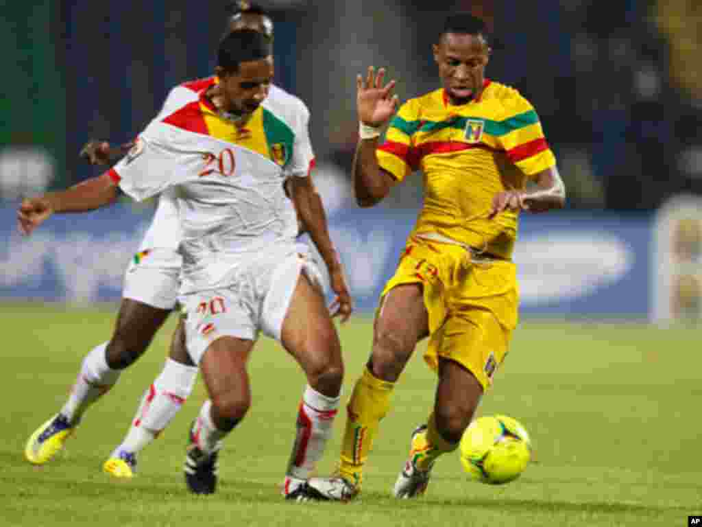 Mali's Seydou Keita challenges for the ball with Guinea's Habib Jean Balde during their African Nations Cup Group D soccer match at Franceville Stadium