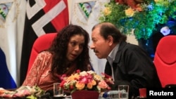 FILE - Nicaraguan President Daniel Ortega speaks with his wife and vice president, Rosario Murillo, during an event to commemorate the 38th anniversary of the founding of the Nicaraguan army, in Managua, Sept. 1, 2017.