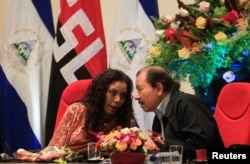 FILE - Nicaraguan President Daniel Ortega speaks with his wife and vice president, Rosario Murillo, during an event to commemorate the 38th anniversary of the founding of the Nicaraguan army, in Managua, Sept. 1, 2017.