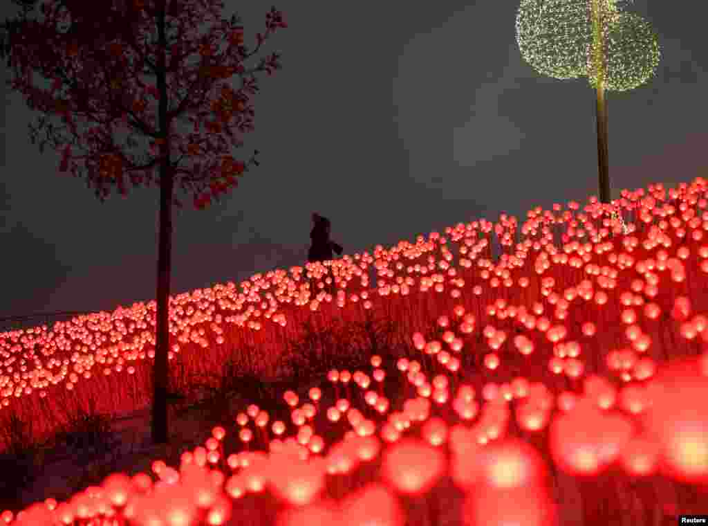 Seorang wanita berjalan melewati dekorasi yang dipasang menyambut liburan Natal dan Tahun Baru di Taman Zaryadye, Moskow, Rusia 30 Desember 2020. (Foto: Reuters)