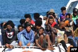Migrants from Tunisia and Lybia arrive onboard an Italian Guardia Costiera (Coast Guard) boat on the Italian Pelagie Island of Lampedusa, Aug. 1, 2020.