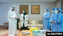 Prime Minister and Vice-President of the United Arab Emirates and ruler of Dubai Sheikh Mohammed bin Rashid al-Maktoum talks to staff before he receives a COVID-19 vaccine candidate, in Dubai, Nov. 3, 2020. (WAM/Handout via Reuters)