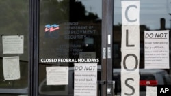 FILE - Information signs are posted at the Illinois Department of Employment Security, June 5, 2020, in Chicago. The federal unemployment rate declined to 13.3 percent in May from 14.7 percent in April with a gain of 2.5 million jobs.