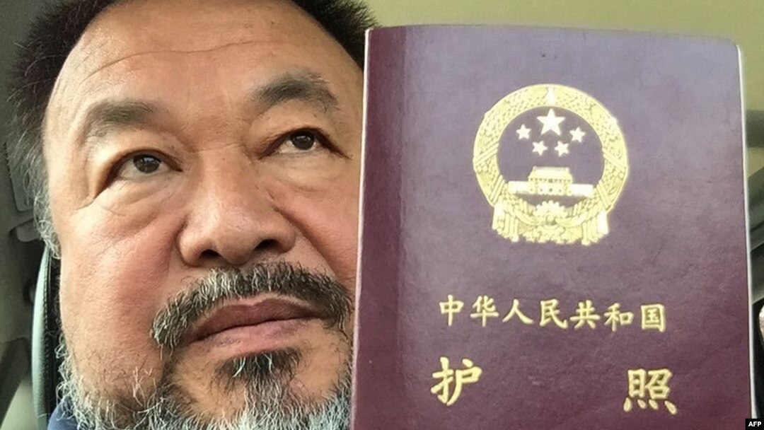 Artis pembangkang China Ai Weiwei menunjukkan paspor miliknya di Beijing hari Rabu (22/7).