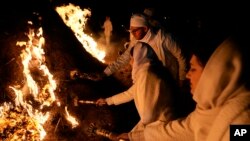 Iranian Zoroastrian youth set fire to a prepared pile of wood in a ceremony celebrating their ancient midwinter Sadeh festival on the outskirts of Tehran, Iran, on Jan. 30, 2024.