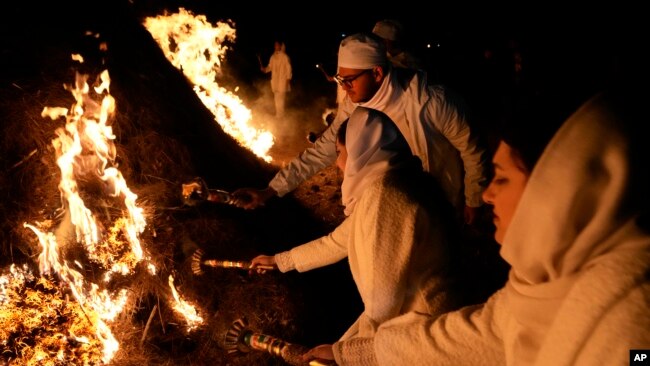 Iranian Zoroastrian youth set fire to a prepared pile of wood in a ceremony celebrating their ancient midwinter Sadeh festival on the outskirts of Tehran, Iran, on Jan. 30, 2024.