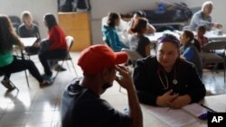 Doctora Psique Calderón, derecha, trabaja con un paciente en un refugio para migrantes en Tijuana, México. 