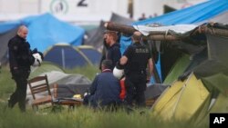 希腊警察在伊多梅尼临时难民营执行任务。