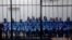 Officials of Moammar Gadhafi's government, including Abdullah al-Senussi (L), ex-spy chief in Moammar Gadhafi's government and Buzeid Dorda (2nd L), ex-intelligence chief, sit behind bars during a hearing at a courtroom in Tripoli, Libya, April 14, 2014.