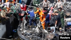 Police, Red Cross and rescue workers remove the remains of victims after a fire ripped through a boat carrying tourists to islands north of the capital, at Muara Angke port in Jakarta, Indonesia Jan. 1, 2017.