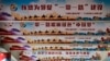 FILE - In this June 29, 2018, photo, a man stands underneath the pillars displaying Chinese President Xi Jinping's signature "China Dream" and "One Belt, One Road" foreign policy plan during an event in Beijing.