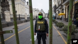 A police officer stands guard one block away from the Constitutional Court building in Lima, Peru, Sept. 17, 2020. 