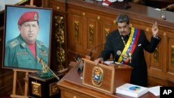 ARCHIVO - El presidente de Venezuela, Nicolas Maduro, junto a un retrato de su predecesor César Chávez, toma la palabra durante una sesión de la Asamblea Nacional, en Caracas, en enero de 2023.