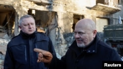FILE: Ukrainian Prosecutor General Kostin (left) and ICC Prosecutor Khan (right) and visit the site of a residential building damaged by a Russian missile strike in Vyshhorod, Ukraine. Taken Feb. 28, 2023. Putin's ICC charges stem from the taking of Ukraine children by Russia. 