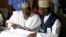 FILE - Independent National Electoral Commission chairman, Attahiru Jega, left, views election results at the coalition center in Abuja, Nigeria, March 30, 2015.