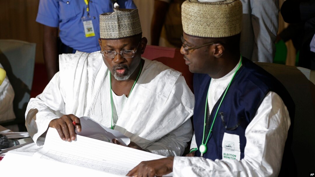 Ketua Komisi Pemilu Independen Nigeria, Attahiru Jega (kiri) memeriksa hail pummel di pusat koalisi di Abuja, Nigeria, 30 Maret 2015 (AP Photo/Sunday Alamba).