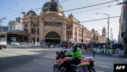 Seorang polisi berpatroli dengan sepeda motor di Melbourne, 12 Februari 2021, setelah pihak berwenang memerintahkan lockdown selama lima hari di seluruh negara bagian mulai tengah malam waktu setempat untuk mencegah penyebaran virus COVID-19. (Foto oleh Con Chronis / AFP)