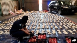 FILE - A Saudi custom officer opens imported pomegranates, as customs foiled an attempt to smuggle over 5 million pills of an amphetamine drug known as Captagon, Apr. 23, 2021. (Saudi Press Agency via AP)