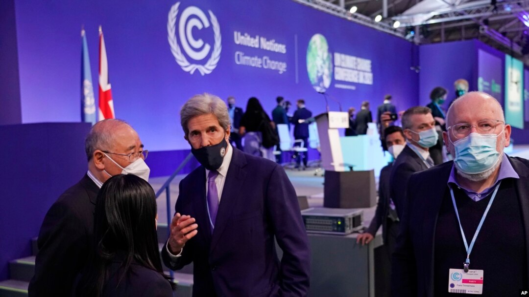 Kepala negosiator China Xie Zhenhua (kiri), berbicara dengan Utusan Khusus Presiden Amerika Serikat untuk Iklim, John Kerry (tengah) saat berlangsungnya sesi pleno inventarisasi KTT Iklim PBB COP26 di Glasgow, Skotlandia, 13 November 2021. (AP/Alberto Pezzali)
