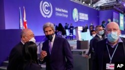 Kepala negosiator China Xie Zhenhua (kiri), berbicara dengan Utusan Khusus Presiden Amerika Serikat untuk Iklim, John Kerry (tengah) saat berlangsungnya sesi pleno inventarisasi KTT Iklim PBB COP26 di Glasgow, Skotlandia, 13 November 2021. (AP/Alberto Pezzali)