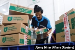 Seorang karyawan mengemas barang di gudang unit e-commerce Tokopedia milik GoTo di Jakarta, 31 Agustus 2022. (Foto: REUTERS/Ajeng Dinar Ulfiana)