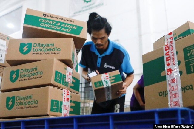 Seorang karyawan mengemas barang di gudang unit e-commerce Tokopedia milik GoTo di Jakarta, 31 Agustus 2022. (Foto: REUTERS/Ajeng Dinar Ulfiana)