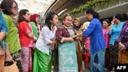 Perempuan Indonesia mendemonstrasikan cara memakai sarung saat mengkampanyekan "Selasa Berkebaya" atau Mengenakan Kebaya pada hari Selasa di Jakarta, 30 Juli 2019. (ADEK BERRY/AFP)