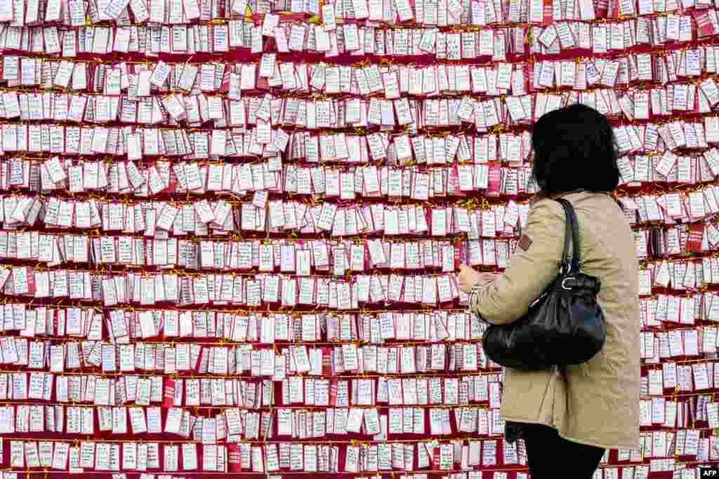 A Buddhist woman places a handwritten note on display as prayers take place at the Jogyesa Buddhist temple for the success of children who at the same time were sitting for the annual nine-hour college entrance exam, locally known as &quot;Suneung,&quot; in Seoul, South Korea.