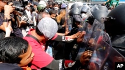 Protesters push during a demonstration near the Asia-Pacific Economic Cooperation forum, Nov. 17, 2022, in Bangkok. Protesters sought to deliver a letter to leaders attending the summit. The letter demanded the removal of Thailand's prime minister, who seized power in 2014.