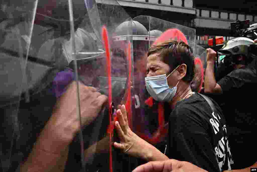 A protester pushes against riot police during a demonstration near the site of the Asia-Pacific Economic Cooperation (APEC) summit in Bangkok, Thailand.