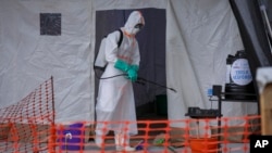 FILE - A medical worker disinfects a tent used for suspected Ebola victims inside the Ebola isolation center of Madudu Health Center III, in the village of Madudu, in the Mubende district of Uganda, Nov. 1, 2022. 