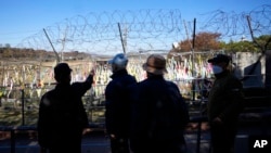 Visitors walk near the wire fences decorated with ribbons with messages wishing for the peace of the two Koreas at the Imjingak Pavilion in Paju, South Korea, Nov. 4, 2022. 