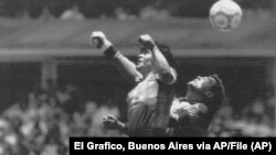 El argentino Diego Maradona, izquierda, supera en el salto al portero inglés Peter Shilton en Ciudad de México, el 22 de junio de 1986. 