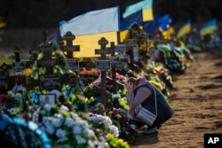 Tamara, 50, meratap di depan makam putra satu-satunya, seorang prajurit militer, yang tewas dalam serangan bom Rusia, di pemakaman di Mykolaiv, Ukraina, pada Rabu, 26 Oktober 2022. (Foto: AP)