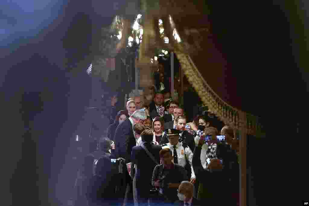 House Speaker Nancy Pelosi of California, center, is surrounded by members of the media as she heads back to her office after speaking on the House floor at the Capitol in Washington.