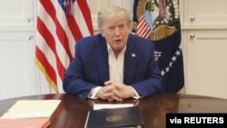 U.S. President Donald Trump, who is being treated for COVID-19 in a military hospital outside Washington, speaks from his hospital room, in this still image taken from a video supplied by the White House, Oct. 3, 2020. 