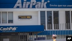 FILE - A candy vendor walks past a Western Union branch in Managua, Nicaragua, Feb. 25, 2023. The fate of Latin American economies, deeply reliant on remittances from the U.S., hangs in the balance with the upcoming U.S. presidential elections, Fitch Ratings said on Friday. 