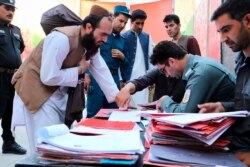 FILE - Taliban prisoners' documents are checked as they are released from Pul-e-Charkhi jail in Kabul, Afghanistan, Aug. 13, 2020.